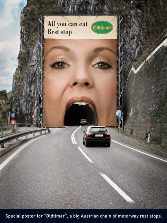 Advertisement of a woman's mouth on a bridge for cars to pass