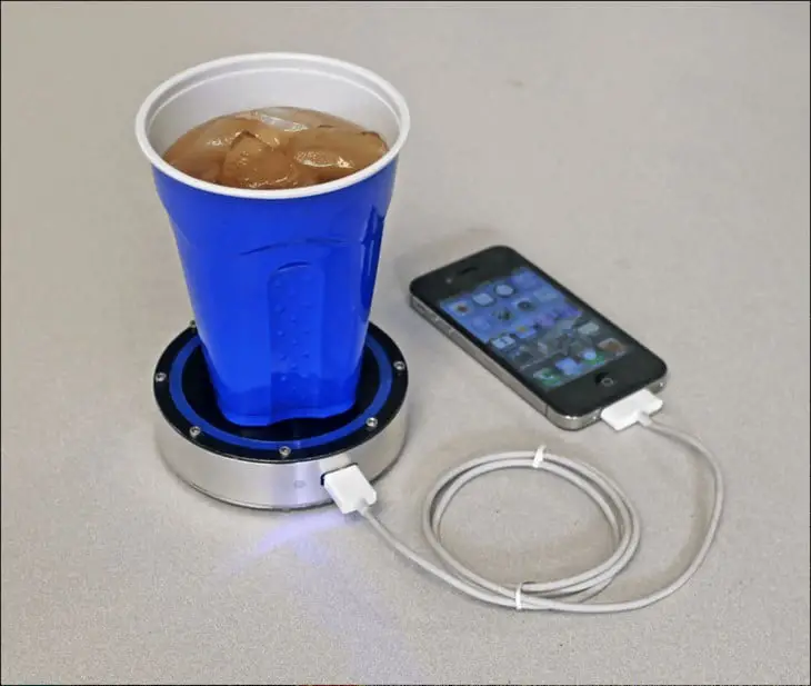 Device that charges the cell phone with hot or cold beverages