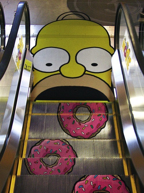 Donut-shaped escalators heading towards a Homer Simpson face