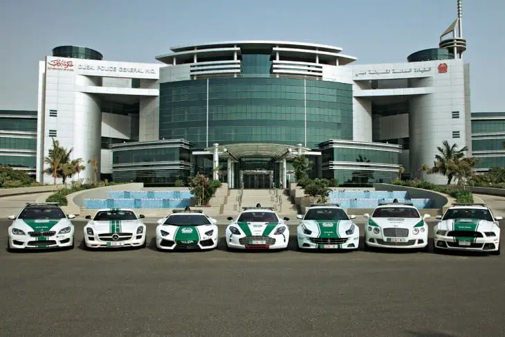 Dubai police patrols parked in front of the façade of the general police directorate in Dubai 