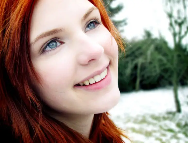 Face of a red-haired girl with blue eyes 