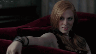 Gif of a vampire girl sitting on a red armchair 