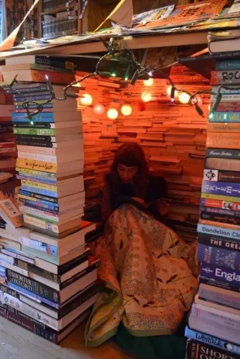 Girl inside a fort made of books