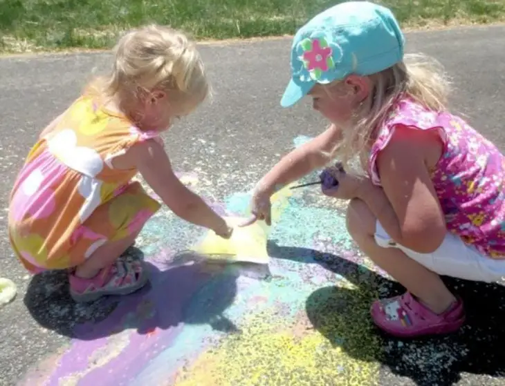 Girls popping paint bags in the playground