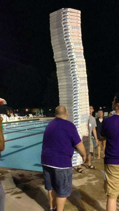 Man carrying a lot of pizzas 