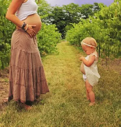 Pregnant Mother And Daughter In The Field