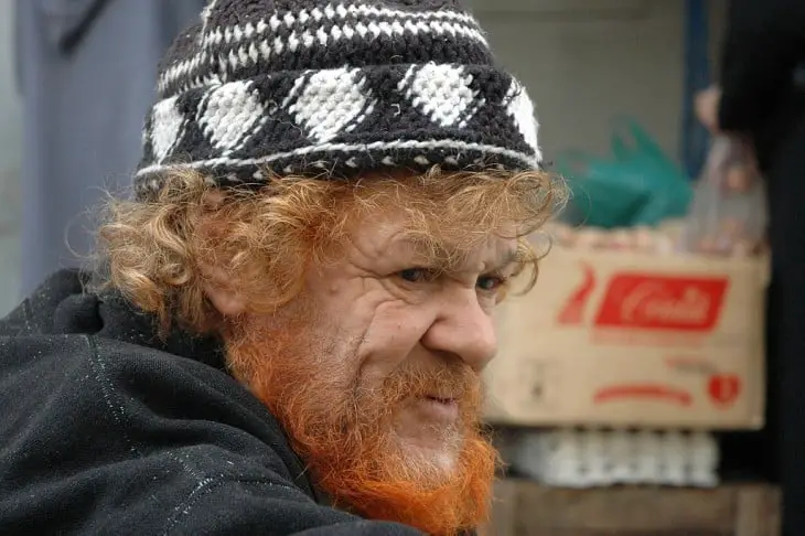 Red-haired old man wearing a tramp hat 