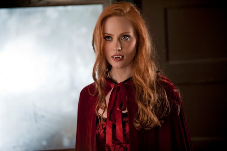 Red-haired woman with vampire teeth and cape 
