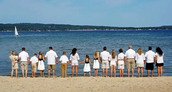 A big family by the sea holding hands 