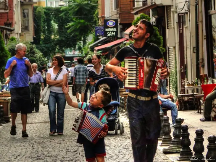 A father standing next to his son with an accordion each 