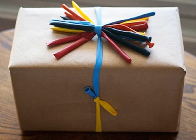 A gift wrapped with colorful balloons 