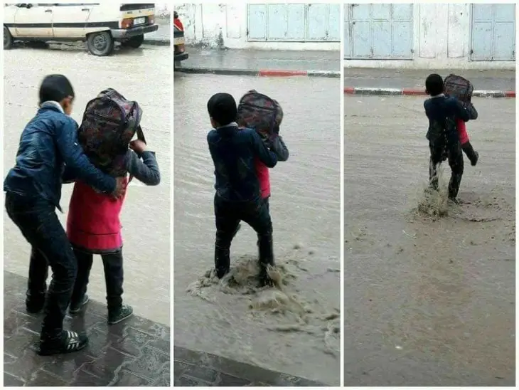 Boy Helps Sister Cross Flooded Street 