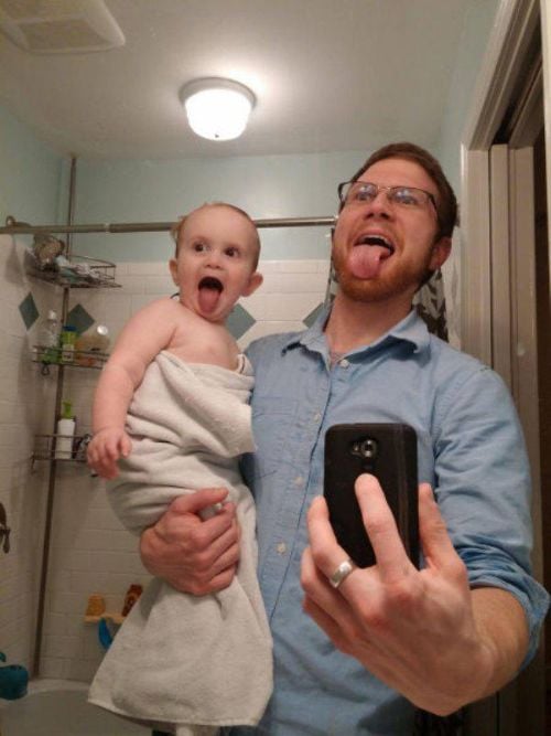 Boy sticking out his tongue like dad for selfie