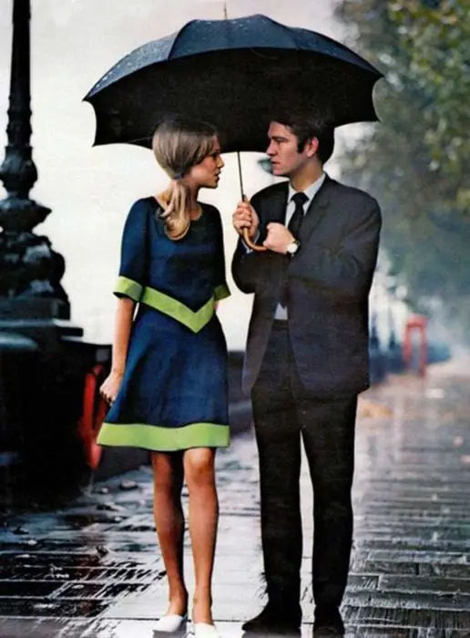 COUPLE WITH UMBRELLA WALKING DOWN THE STREET