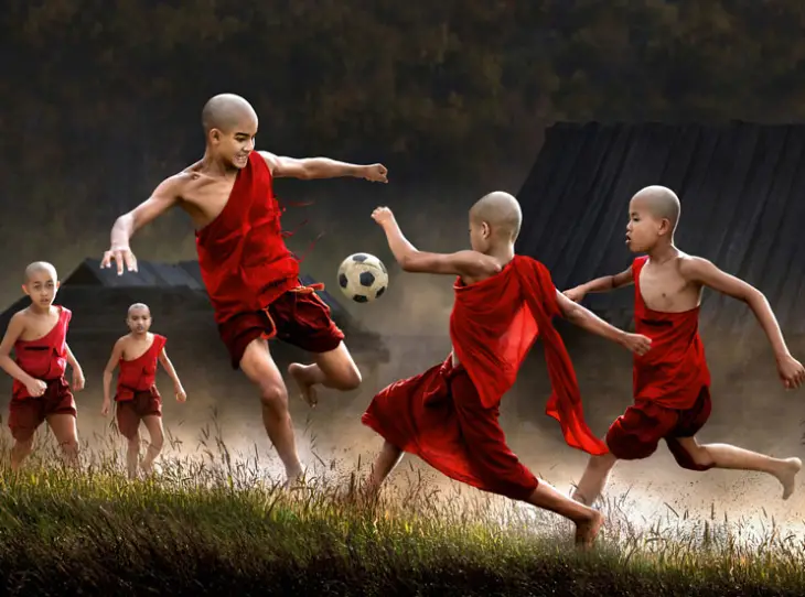 Children dressed in red playing with a ball