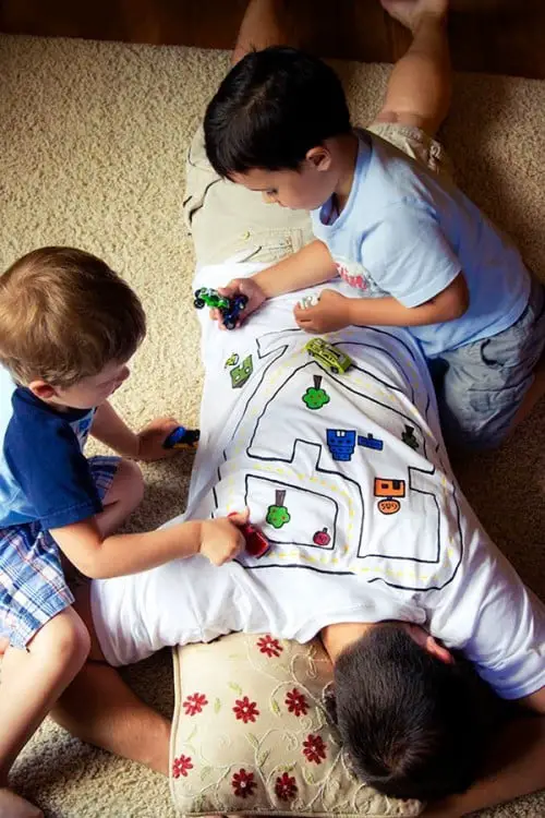 Dad Wears T-shirt in the shape of a path to entertain his kids while taking a nap