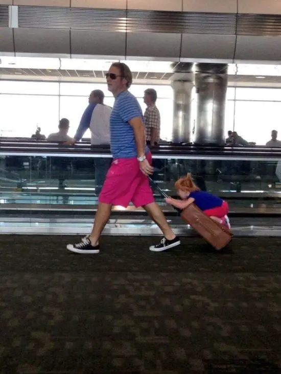 Dad carries his daughter in his suitcase while dragging her like a cart