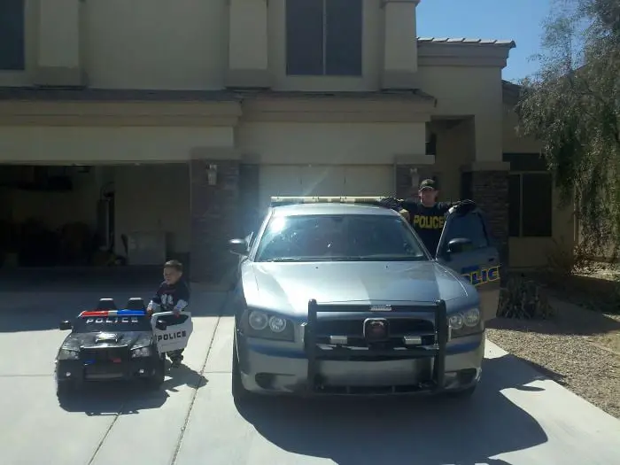 Father and son getting into a police car 