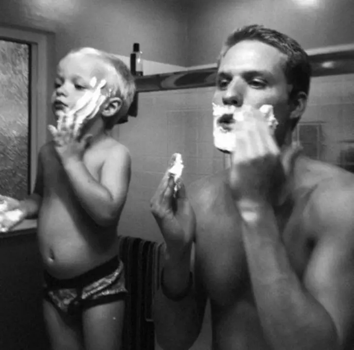 Father and son shaving in front of a mirror 