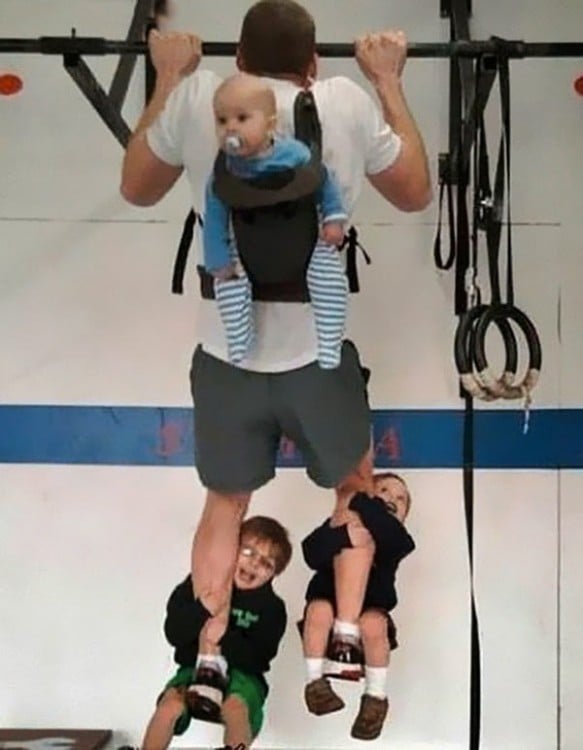 Father pull-up as he carries his children on his back and legs