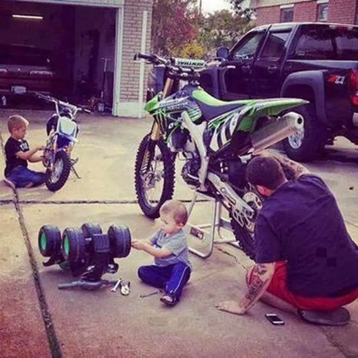 Father with his children fixing their motorcycles 