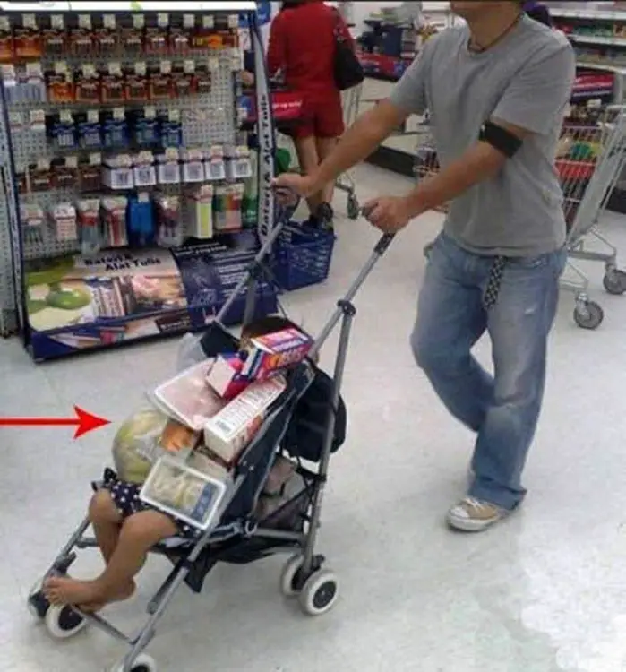 Man carrying his baby with supermarket shopping over his son 