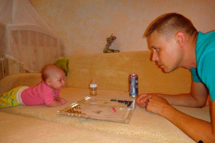 Man in front of his daughter with a board game between them 