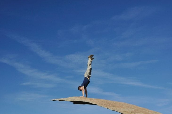 Man standing on his hands on a rock