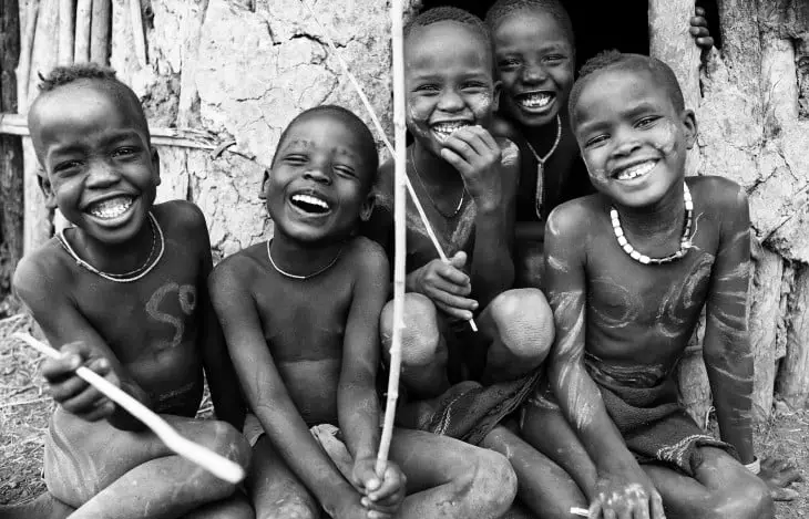 Photograph of children of a tribe in Ethiopia happy and smiling 