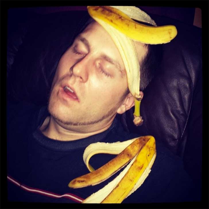 Sleeping man with banana peels on his head and shoulder 