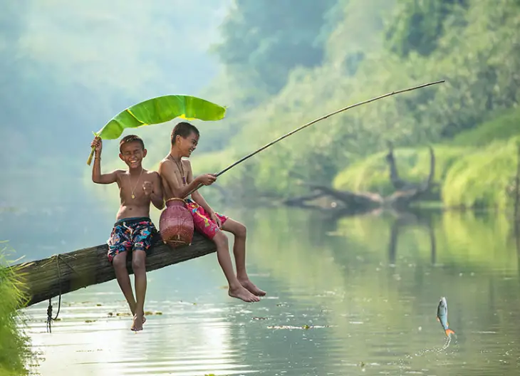 Two children fishing in a river